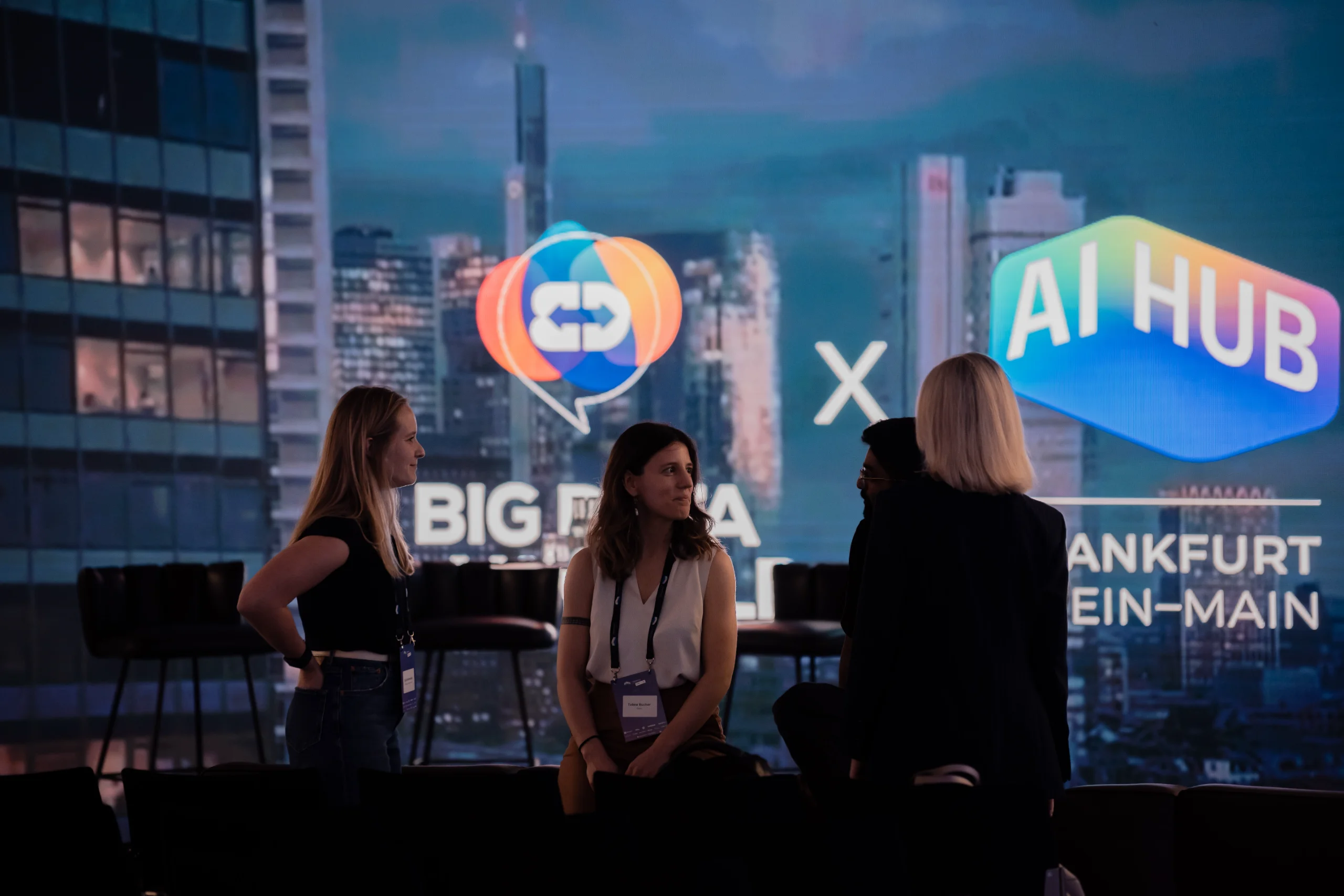 Guests networking on the floor in front of the LED skyline